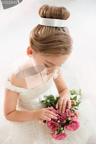 Image of The little balerina in white tutu in class at the ballet school