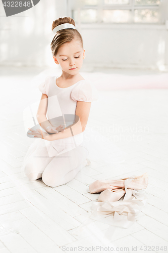 Image of The little balerina in white tutu in class at the ballet school