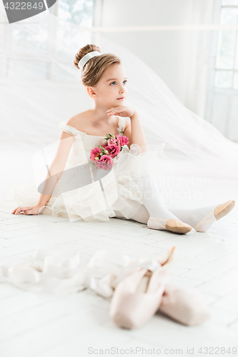 Image of The little balerina in white tutu in class at the ballet school