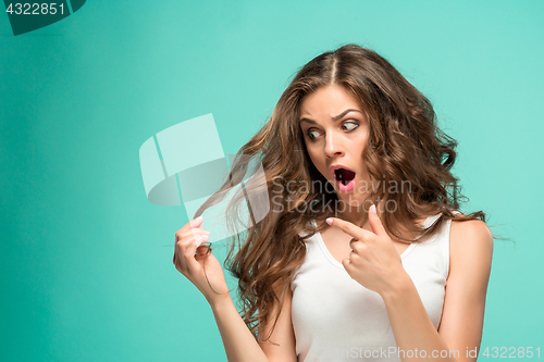 Image of Frustrated young woman having a bad hair on blue