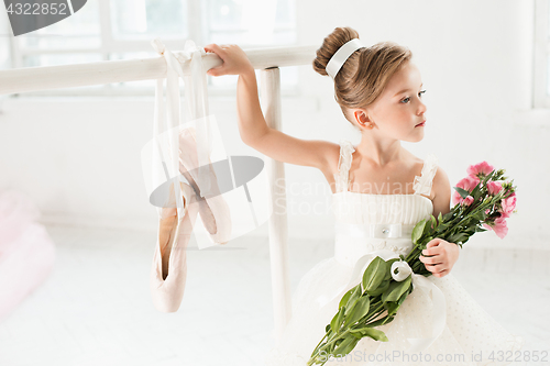 Image of Little ballerina girl in a tutu. Adorable child dancing classical ballet in a white studio.