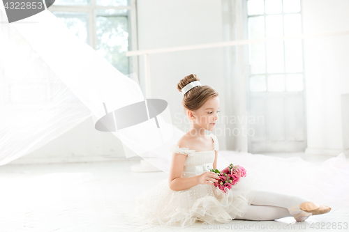 Image of The little balerina in white tutu in class at the ballet school