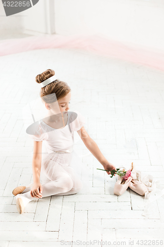 Image of The little balerina in white tutu in class at the ballet school