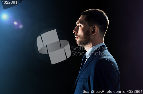 Image of businessman over black background with lens flare