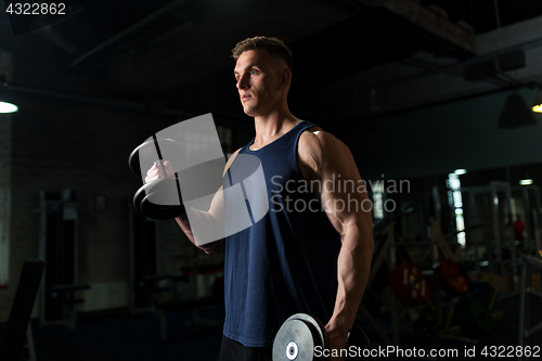 Image of young man with dumbbells exercising in gym