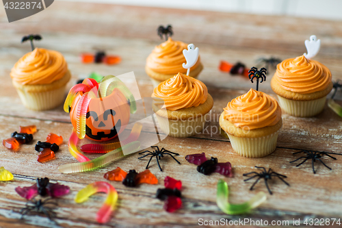 Image of halloween party decorated cupcakes on wooden table