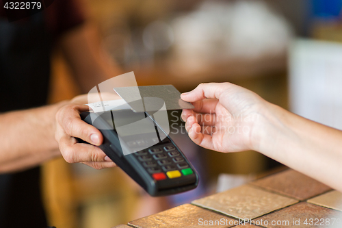 Image of hands with payment terminal and credit card