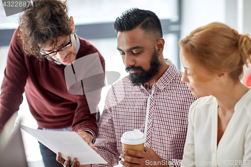 Image of business team with papers and coffee at office