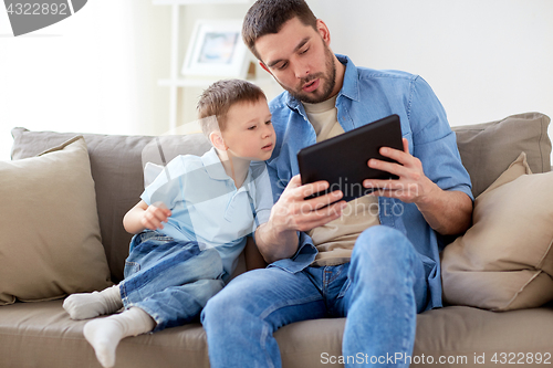 Image of father and son with tablet pc playing at home