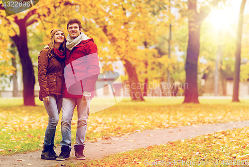 Image of happy young couple walking in autumn park