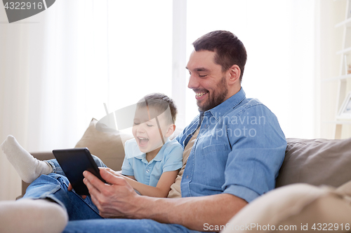 Image of father and son with tablet pc playing at home