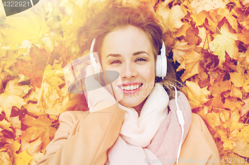 Image of woman with headphones listening to music in autumn