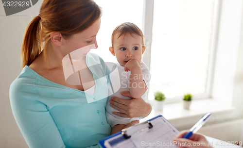 Image of happy woman with baby and doctor at clinic