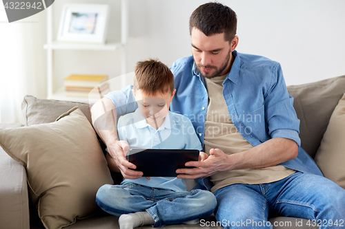 Image of father and son with tablet pc playing at home