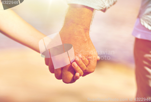 Image of senior man and child holding hands