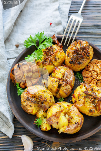 Image of Potatoes baked with garlic,thyme and green parsley.