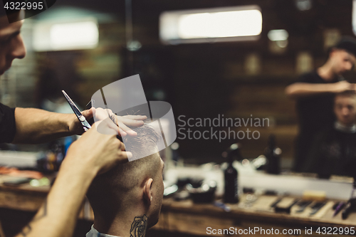 Image of Crop barber doing haircut for client