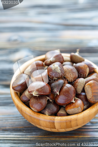 Image of Wooden bowl with fresh chestnut.