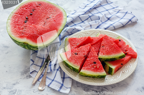 Image of Half of watermelon and a dish of sliced watermelon.