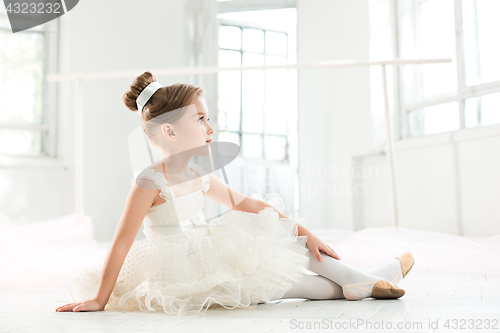 Image of The little balerina in white tutu in class at the ballet school