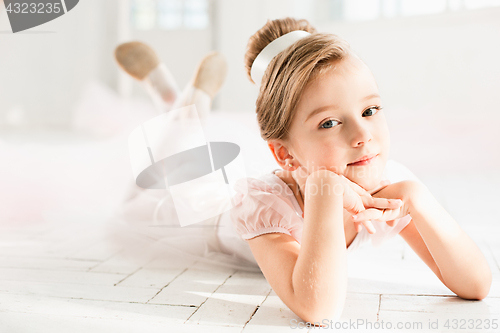 Image of The little balerina in white tutu in class at the ballet school