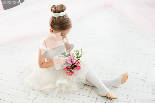 Image of The little balerina in white tutu in class at the ballet school