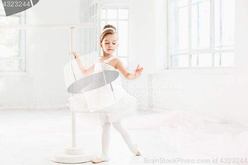 Image of Little ballerina girl in a tutu. Adorable child dancing classical ballet in a white studio.