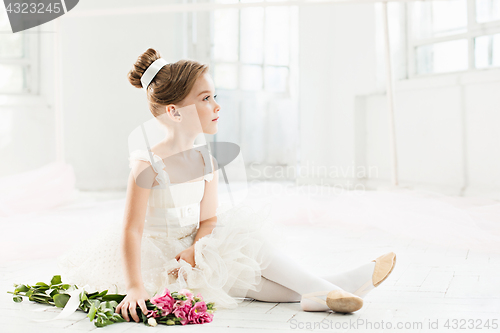Image of The little balerina in white tutu in class at the ballet school