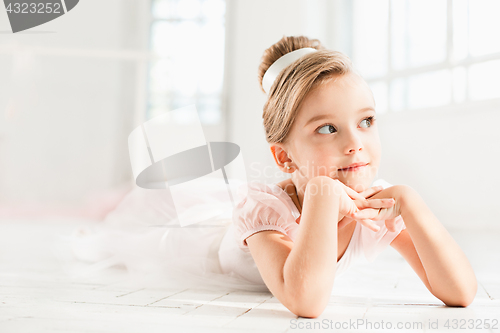 Image of The little balerina in white tutu in class at the ballet school