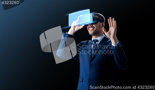 Image of businessman in virtual reality headset over black