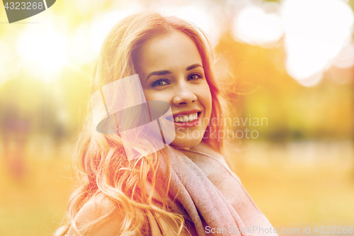 Image of beautiful happy young woman smiling in autumn park