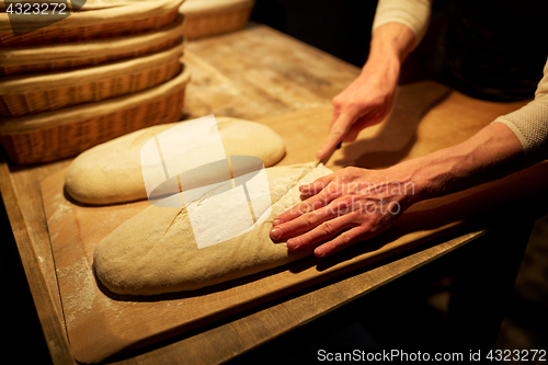 Image of chef or baker with dough cooking bread at bakery