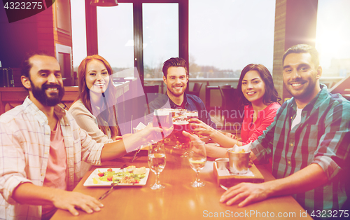 Image of friends dining and drinking beer at restaurant