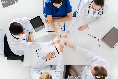 Image of group of doctors showing thumbs up over table