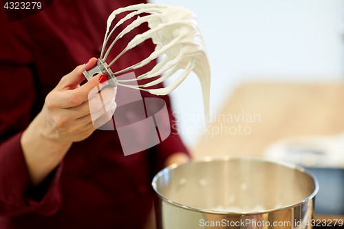 Image of chef with whisk and whipped egg whites at kitchen