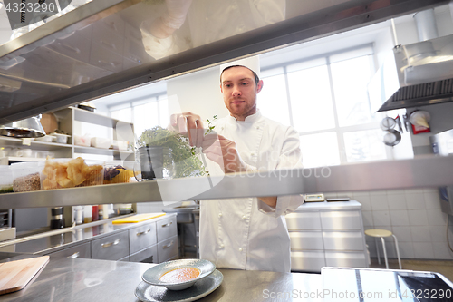 Image of happy male chef cooking at restaurant kitchen