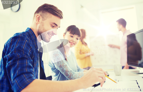 Image of creative team with blueprint at office