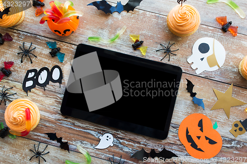 Image of tablet pc, halloween party decorations and treats