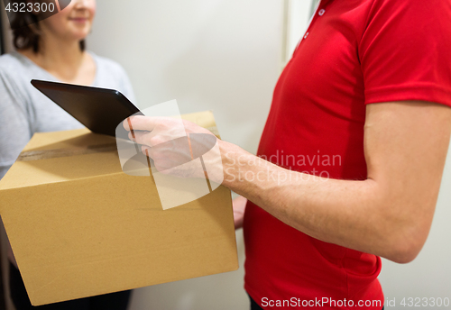 Image of delivery man with box, tablet pc and customer