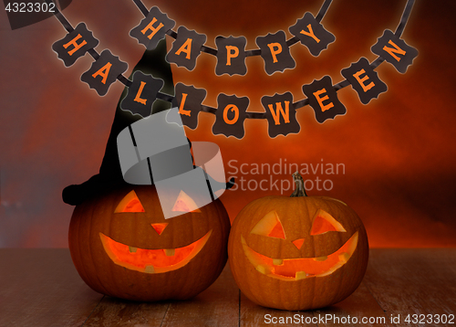 Image of carved pumpkins and happy halloween garland