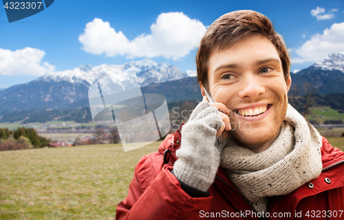 Image of man calling on smartphone over alps mountains