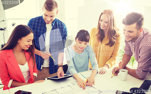 Image of creative team with blueprint working at office