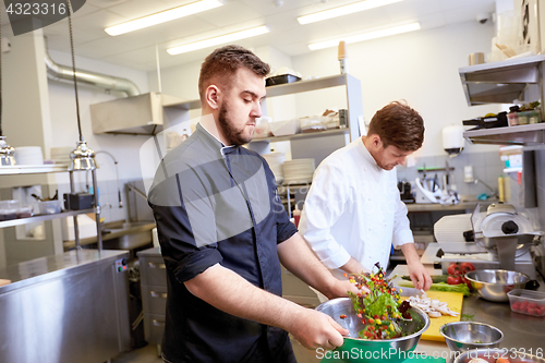 Image of chef and cook cooking food at restaurant kitchen