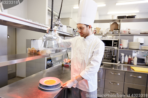 Image of happy male chef cooking food at restaurant kitchen