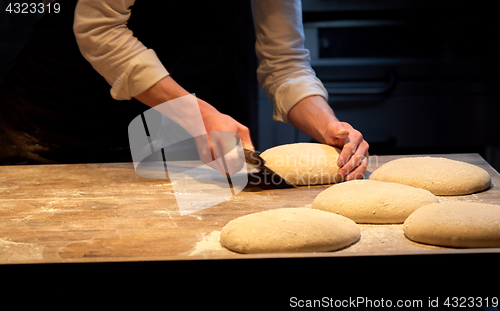 Image of baker portioning dough with bench cutter at bakery