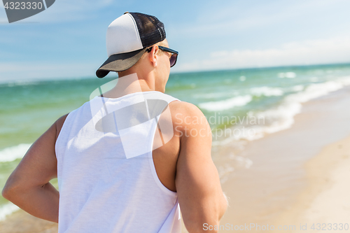 Image of happy man running along summer beach