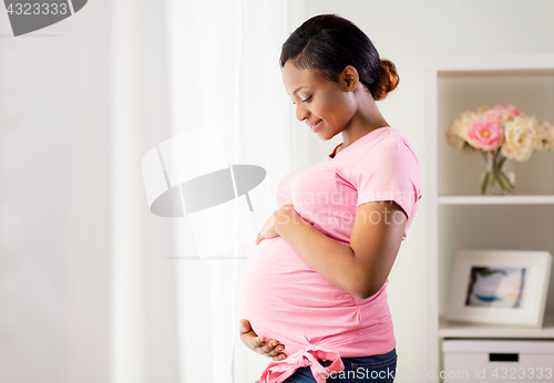 Image of happy pregnant woman with big belly at home