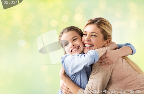 Image of happy girl with mother hugging over lights