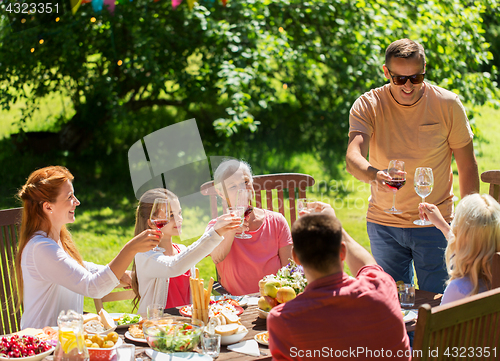 Image of happy family having dinner or summer garden party