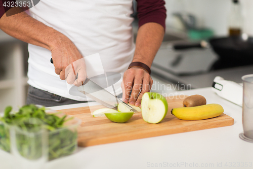 Image of man chopping fruits and cooking at home kitchen